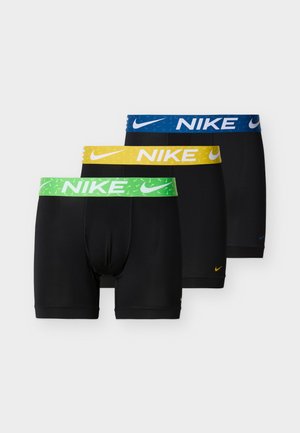 Drei schwarze Nike Boxershorts mit elastischen Bunds in Grün, Gelb und Blau, jeweils mit dem Nike-Logo und Swoosh versehen.