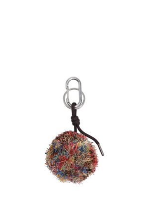 Llavero colorido y esponjoso con pompón, unido a un mosquetón plateado con un lazo de cordón negro anudado.