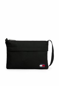 Borsa a pochette in tessuto nero con chiusura a zip, manico da polso e una piccola toppa logo multicolore con la scritta "TOMMY JEANS" sul fronte.