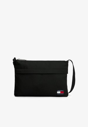 Czarna torebka kopertówka z zamkiem błyskawicznym, paskiem na nadgarstek oraz małą, wielokolorową łatą z logo "TOMMY JEANS" z przodu.