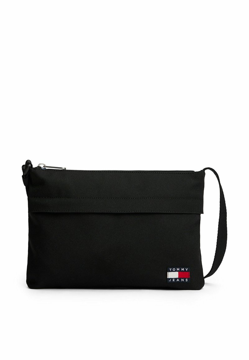 Borsa a pochette in tessuto nero con chiusura a zip, manico da polso e una piccola toppa logo multicolore con la scritta "TOMMY JEANS" sul fronte.