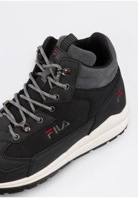 Czarne wysokie sneakersy Fila z teksturowanym materiałem, szarymi akcentami, szarymi sznurówkami oraz białą gumową podeszwą z wzorzystym bieżnikiem.