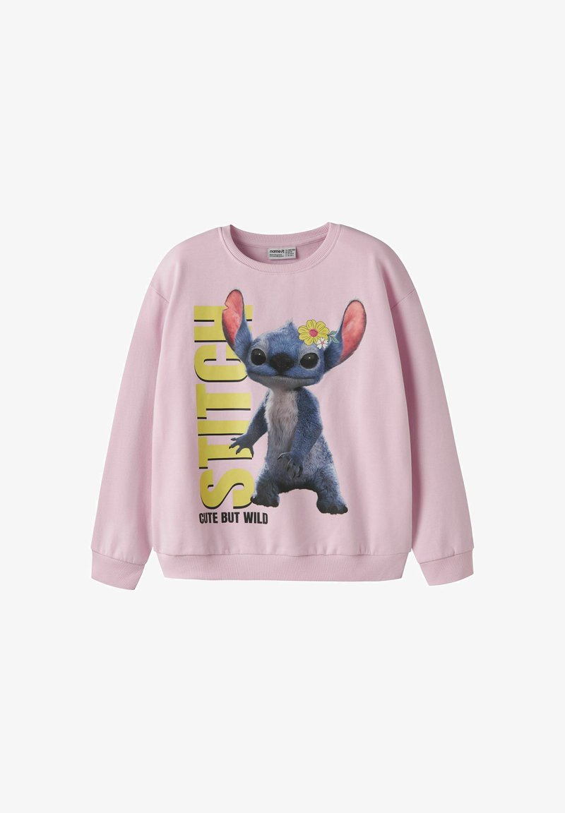 Sweat-shirt rose clair avec le personnage Stitch avec une fleur jaune à l'oreille, grand texte jaune et la phrase "Cute but wild."