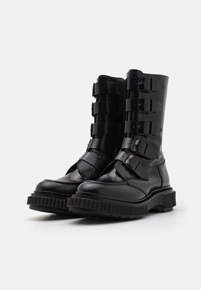 Black leather combat boots with five buckled straps, a rounded toe, and a thick textured sole. Smooth finish and sturdy design.