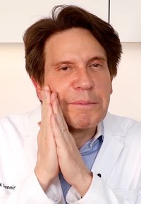 Manlig figur i en vit labbrock med en blårandig skjorta, händerna på ansiktet, håret bakåtslickat, neutral bakgrund, koncentrerat uttryck.