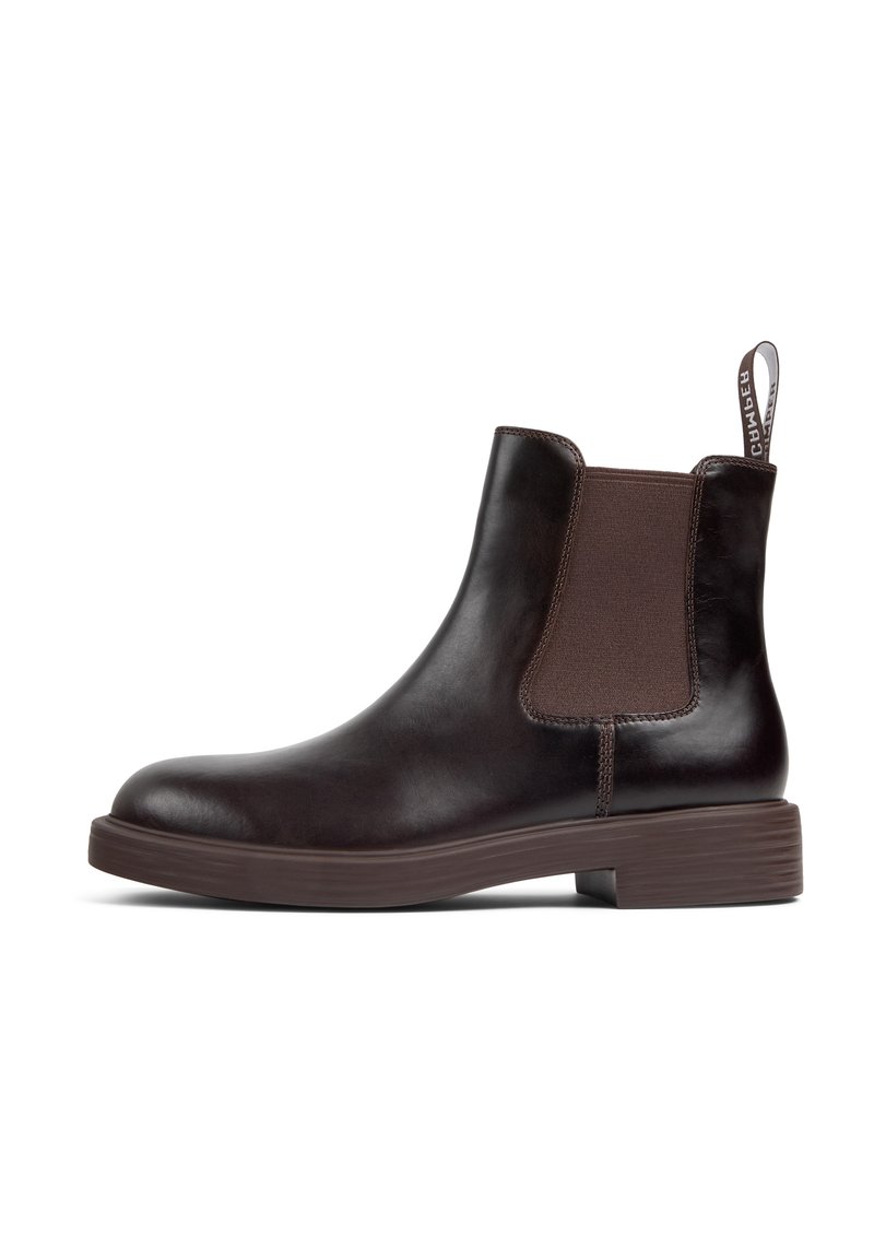 Bottine Chelsea en cuir marron avec des panneaux latéraux élastiques et une languette. Elle présente un bout arrondi et un talon en caoutchouc texturé bas.