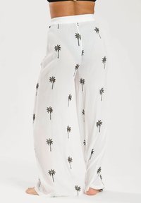 Białe, lekkie spodnie z nadrukiem palm w czerni i złocie. Posiadają miękki, elastyczny pas w talii oraz luźny krój.