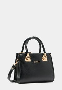Sac à main en cuir noir avec une finition texturée, quincaillerie dorée, poignées tressées et une sangle amovible. Présente un logo estampé sur le côté.