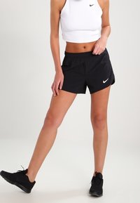 Pantalones cortos deportivos negros con cintura elástica y bolsillos laterales, fabricados con material ligero. Presentan un pequeño logo blanco de Nike en la parte delantera.