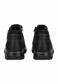 Schwarze Stiefeletten mit glattem Lederobermaterial, textilem Futter, Reißverschlüssen an beiden Seiten und einer strukturierten Gummisohle.