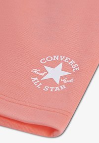 Ύφασμα βαμβακιού κοραλί με ραβδωτή υφή, που διαθέτει λευκό λογότυπο "Converse All Star" και σχέδιο αστεριού στη γωνία στο κάτω μέρος.
