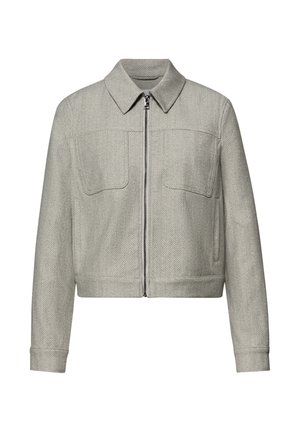 Veste zippée gris clair à chevrons avec col pointu, manches longues et deux poches poitrine, présentée sur fond blanc.