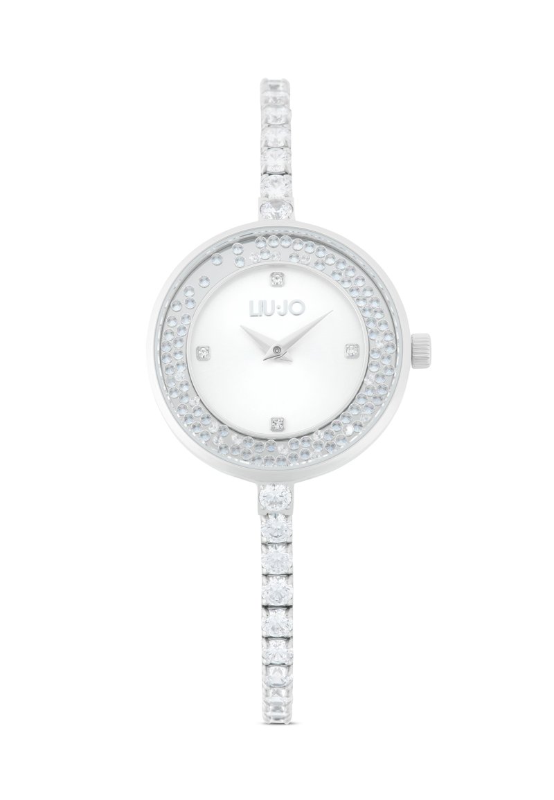 Reloj plateado con esfera redonda, acentos de cristal claro alrededor del bisel y la correa, y un dial minimalista blanco con manecillas plateadas y el logotipo.