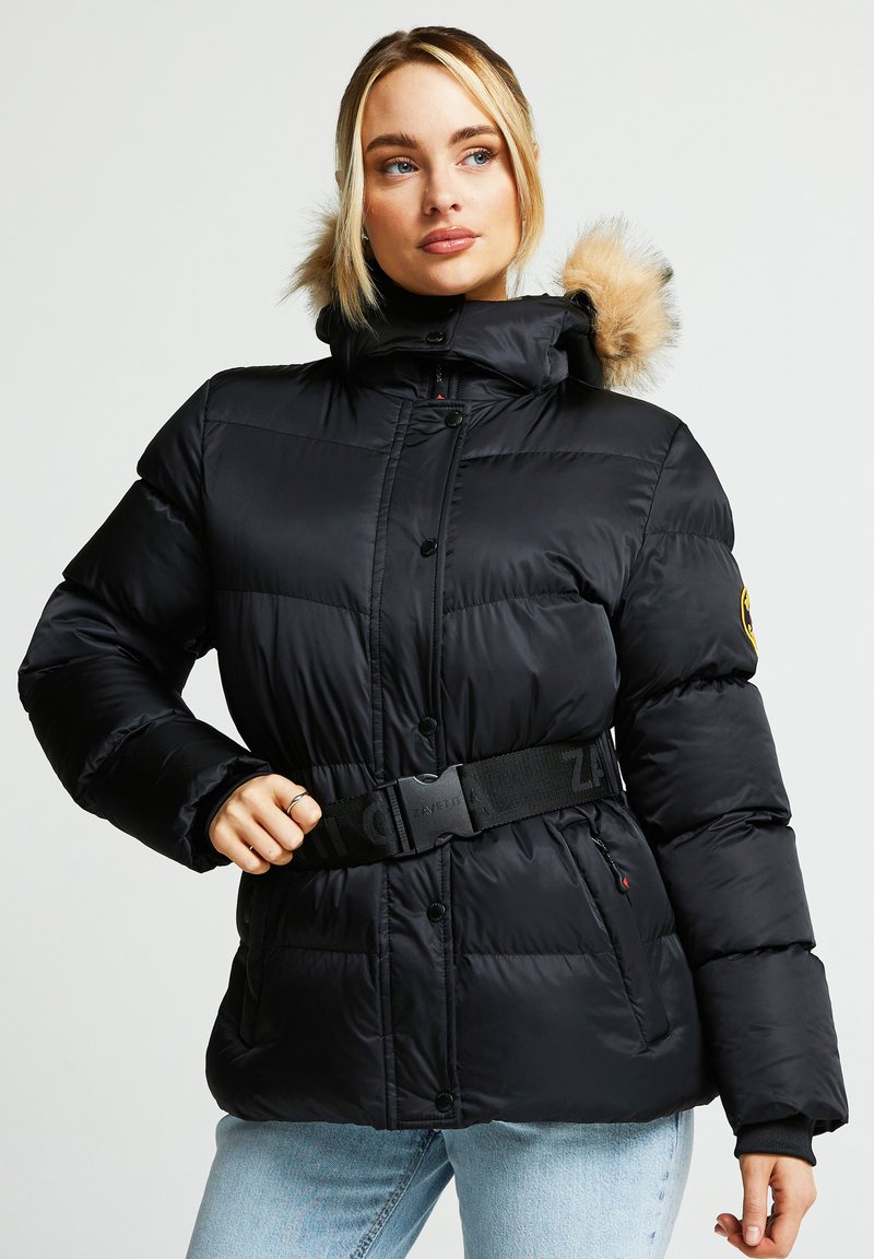 Svart puffjakke med innsvingt midje, hette foret med pels og knappelukking. Har tykk tekstur og justerbart belte med merke.