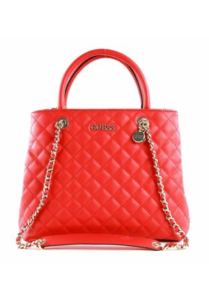 Sac à main en cuir rouge matelassé avec poignées supérieures et bandoulière chaîne dorée, avec logo Guess et pendentif métallique rond.