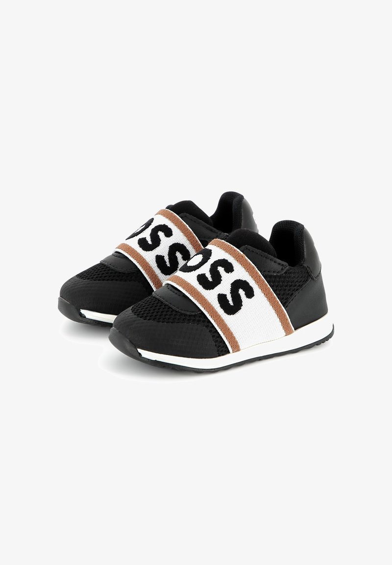 Zwarte sportieve schoenen met een bovenwerk van mesh, brede elastische banden met opvallende letters, contrasterende bruine en witte accenten, en rubberen zolen.