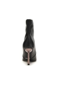 Bottines noires avec un extérieur en cuir lisse, un talon circulaire et un minimum de détails en métal. Texture lisse et design à talon haut.