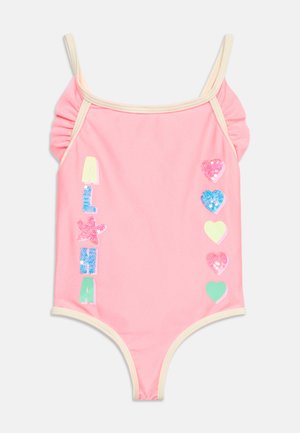 Bañador rosa sin mangas para niño pequeño con ribete crema, tirantes con volantes, letras "ALHA", estrella y cinco lentejuelas de colores en forma de corazón en el frente.