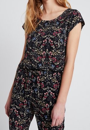 Combinaison fleurie avec un fond noir ornée de motifs floraux multicolores, des manches courtes et une taille élastique avec un détail de nœud.