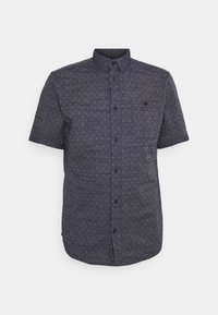 Camisa de manga corta azul oscuro con estampado, cuello abotonado, bolsillo frontal y botones negros. Tejido texturizado con un diseño geométrico sutil.