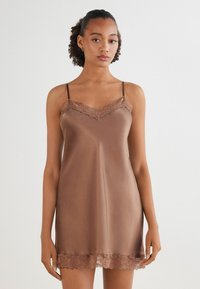 Brun satin klänning med spetskant vid urringningen och fåll, med tunna justerbara band och en mjuk, något glänsande yta.