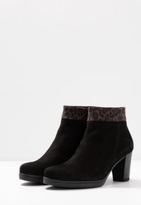 Stivaletti neri in suede con un risvolto a stampa leopardata, con un tacco spesso e una superficie liscia. Design senza lacci con una silhouette elegante.