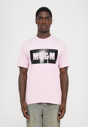Short-sleeve pink t-shirt features a black rectangular graphic with "MSGM" in white letters. Soft cotton material, relaxed fit.