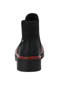 Botín de cuero negro con punta redondeada, detalles rojos a lo largo de la suela y un detalle de botón. Textura suave con un tacón bajo.