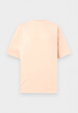 Rövid ujjú, kerek nyakú póló egyszínű világos barack színben, laposan elhelyezve semleges szürke háttéren.