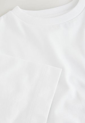 Biały T-shirt z krótkim rękawem, z prążkowanym, okrągłym dekoltem i gładką fakturą materiału, o prostym wzorze bez widocznych nadruków.