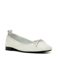 Bailarina de cuero blanco con punta afilada, pequeño lazo en la parte delantera y un bajo tacón negro. Suave forro interior texturizado.