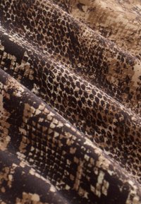 Fabric with a dark brown and beige snake skin pattern, showcasing various textures and scales arranged in irregular, organic lines.