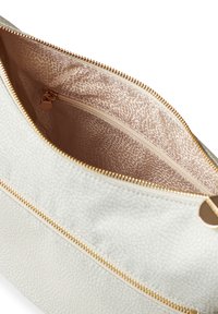 Light-colored leather bag with a textured surface, gold zipper, and a patterned beige lining featuring a smaller zipped pocket inside.