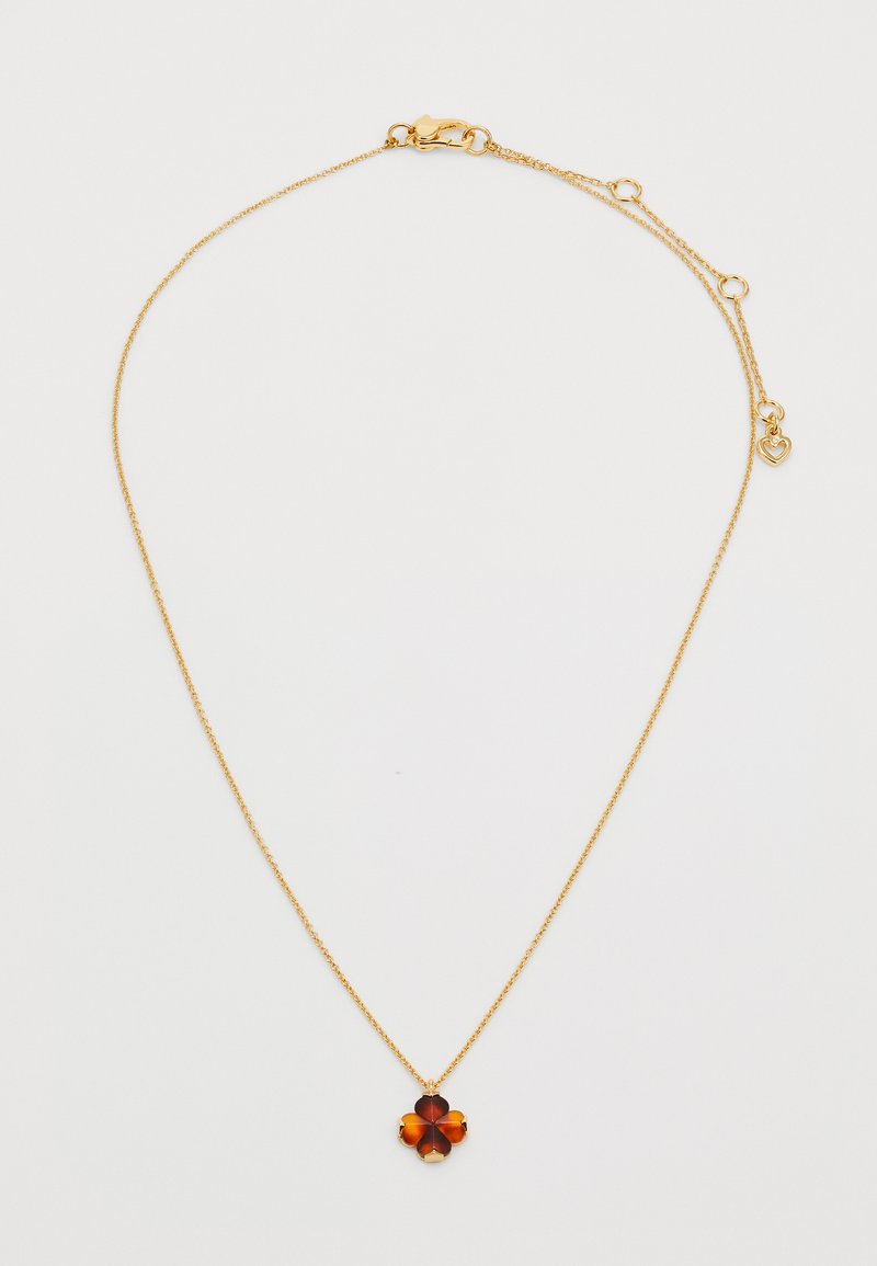 Zlatna verižica s pendantom v obliki cvetnega lista rjave barve, ki ima štiri plasti, pritrjena z zlatim okovjem, nastavljive dolžine z dodatkom v obliki srca.