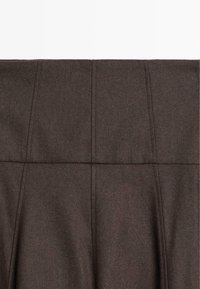 Gonna in misto lana marrone con un design plissettato, dettagli di cucitura a vista e una texture liscia. Adatta per varie occasioni.