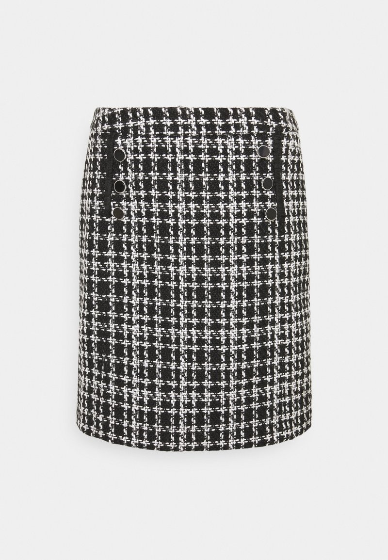 Mini-jupe en tweed noir et blanc avec un motif quadrillé, présentant deux rangées verticales de trois boutons noirs sur les côtés avant.