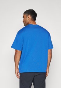 Under Armour HEAVYWEIGHT OVERSIZED BOX LOGO - Sports T-shirt - tech blue/horizon blue