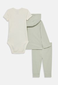 Dreiteiliges Baby-Outfit bestehend aus einem cremefarbenen Kurzarm-Body, einem hellgrünen, gerippten Langarm-Hoodie und passenden Hosen.