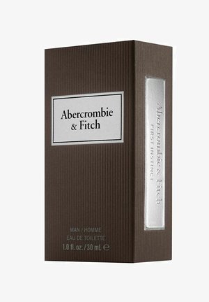 Brun ribbad låda med en silveraccent och etikett i vitt. Texten lyder "Abercrombie & Fitch First Instinct" och inkluderar produktinformation längst ner.