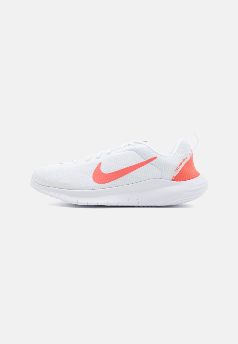 Bijele atletske cipele s teksturiranim mrežastim gornjim dijelom, ružičastim detaljima, zaobljenim prstima i fleksibilnom gumenom potplatu. Sadrže Nike logo na strani.