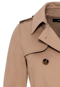 Trench-coat beige avec un col classique, une fermeture à bouton sur le devant et des épaulettes. Texture lisse et tissu léger.