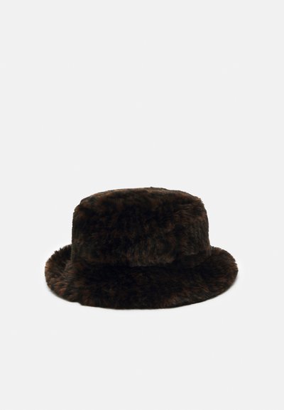 Brūns mākslīgā kažokāda bucket cepure ar mīkstu, teksturētu virsmu, noapaļotu kroni un plašu, plakanu malu. Kopējā cilindriskā forma.