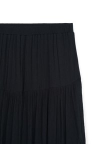 Gonna maxi nera con un design plissettato, caratterizzata da una vita liscia e un tessuto leggero. Silhouette semplice e fluida.
