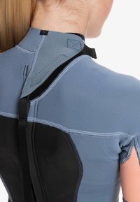 Short-sleeve wetsuit featuring a smooth blue neoprene body and black accents. Includes a hook-and-loop closure and reinforced stitching details.