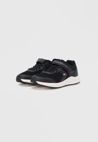 Scarpe da ginnastica nere con tomaia in mesh, colletto imbottito e suola intermedia bianca. Presentano una fascia e un accento con logo sul lato.