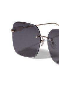 Négyzet alakú napszemüveg sötétszürke lencsékkel, aranyszínű fém kiegészítőkkel és átlátszó orrpárnákkal, letisztult dizájnnal.