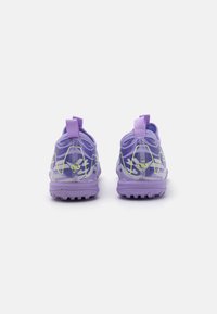 Scarpe da ginnastica viola con una suola in gomma testurizzata, dotate di una tomaia in rete, pratiche linguette per il sollevamento e dettagli gialli in un motivo ondulato.