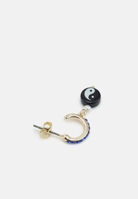 Brinco de argola dourado com strass azuis, apresentando um charme yin-yang preto e um detalhe de pérola. O design é circular com uma superfície texturizada.