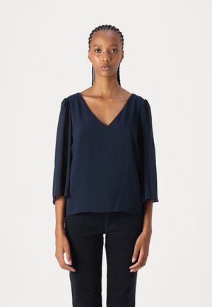 Navy blue, V-neck blouse with three-quarter sleeves, made from lightweight fabric; features subtle draping at sleeves and a relaxed fit.