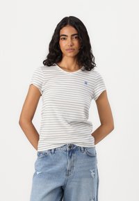 Dryžuota trumpomis rankovėmis t-shirt baltoje ir tamsiai mėlynoje spalvose, su apvaliu iškirpimu ir mažu mėlynu logotipu krūtinėje, pagaminta iš lengvo audinio.